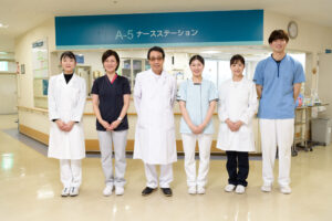 医療・介護スタッフが施設内で集合写真を撮影している様子